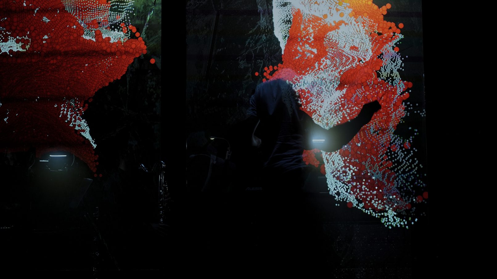 conductor behind screens showing abstract audio-reactive visuals