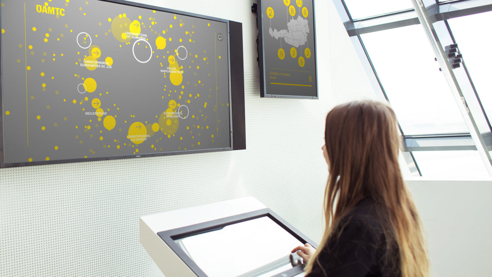 child in front of multiple screens showing real time data