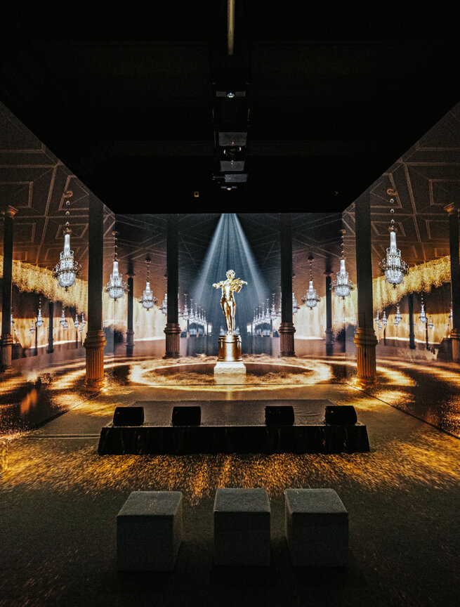 Visitors experience an immersive digital installation with large-scale projections of abstract, motion-blurred figures at the Strauss – New Dimensions exhibition, produced by Bildwerk.